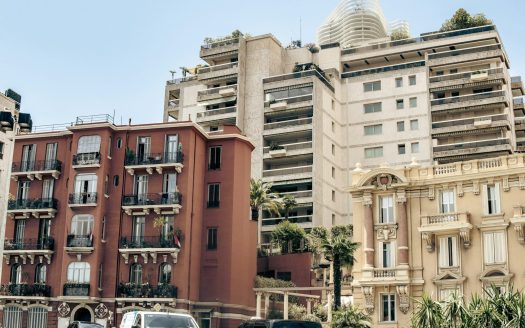 A group of buildings with cars parked in front of them