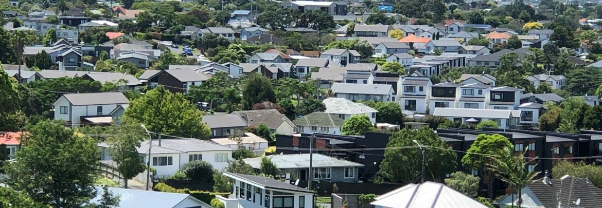 Suburban neighborhood with houses and green hills.