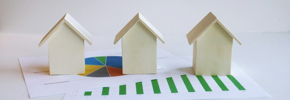 three small houses sitting on top of a piece of paper