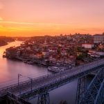 gray bridge near building at sunset