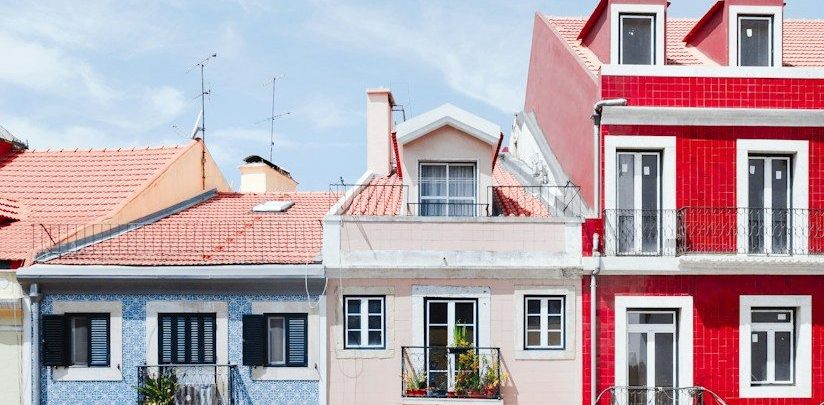 Colorful residential buildings with tiled facades on a sloped street in Lisbon