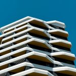 Modern building with unique angular balconies against clear blue sky