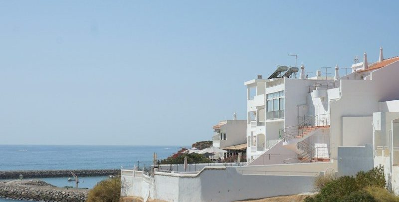White buildings on a cliff overlooking the ocean